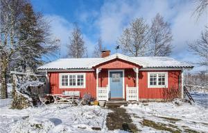 ein rotes Haus mit schneebedecktem Dach im Schnee in der Unterkunft 2 Bedroom Beautiful Home In Mullsj in Mullsjö