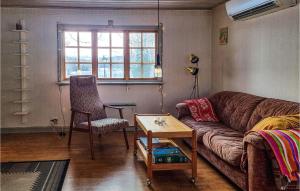 een woonkamer met een bank, een stoel en een tafel bij Amazing Home In Mullsj With 2 Bedrooms in Mullsjö