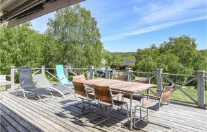 una terraza de madera con mesa y sillas de madera en Awesome Home In Hjlteby With Wifi en Hjälteby