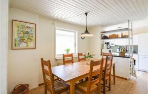 cocina y comedor con mesa de madera y sillas en Awesome Home In Hjlteby With Wifi en Hjälteby