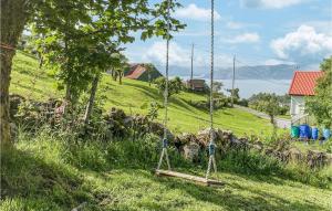 a swing in the grass in a field at 4 Bedroom Gorgeous Home In Vanse in Vanse