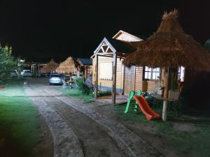 uma pequena casa com um parque infantil e um parque de diversões à noite em Aires de Tafi em Tafí del Valle