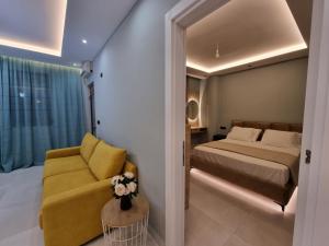 een slaapkamer met een bed en een gele stoel bij Holiday apartment near the sea in Durrës