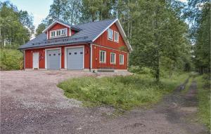 eine rote Scheune mit zwei Garagentüren auf einem Grundstück in der Unterkunft 2 Bedroom Gorgeous Apartment In rjng in Årjäng