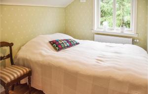 ein Schlafzimmer mit einem weißen Bett und einem Kissen darauf in der Unterkunft 2 Bedroom Gorgeous Apartment In rjng in Årjäng
