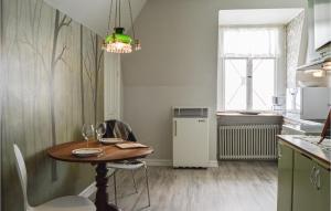 a kitchen with a wooden table and a dining room at Beautiful Apartment In Nynshamn With Kitchen in Nynäshamn