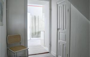 an empty hallway with a chair and an open door at Beautiful Apartment In Nynshamn With Kitchen in Nynäshamn