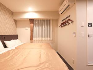 Postel nebo postele na pokoji v ubytování HOTEL LiVEMAX Shinyokohama