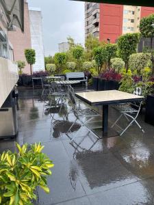 a table and chairs on a patio in the rain at Cozy Stylish room in Polanco in Mexico City