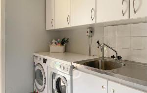 a kitchen with a sink and a washing machine at Cozy Home In Osby With Wifi in Osby