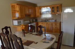 a kitchen with a table and a white refrigerator at The Terraces at Mangrove in Saint Philip