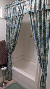 a bathroom with a shower curtain and a bath tub at Pierce's Cabin in Miramonte +20 photos