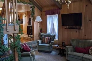 a living room with two chairs and a flat screen tv at Pierce's Cabin in Miramonte