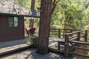 a wooden deck with a tree and a bench at Pierce's Cabin in Miramonte