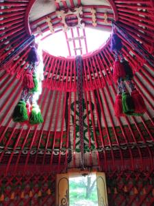 une fenêtre dans un bâtiment rouge avec une croix dans l'établissement Turan Handmade Yurt with Heated Floors, à Karakol