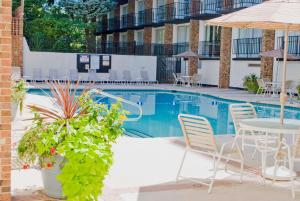 a pool at a hotel with chairs and tables and an umbrella at Hawthorne Inn & Conference Center in Winston-Salem