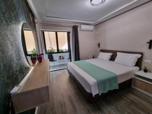 een slaapkamer met een groot bed en een groot raam bij Lovely new apartment near Tirana's artificial Lake in Tirana