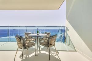 einen Tisch und Stühle auf einem Balkon mit einer Flasche Wein in der Unterkunft SUNSET DRIVE by Costa Activa Rentals in Benidorm