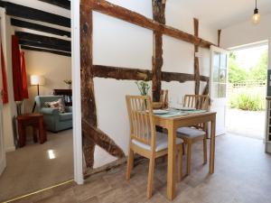 a dining room with a wooden table and chairs at Mortons Cottage in Castlemorton +27 photos