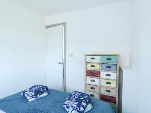 スケッグネスにある57 Cherry Parkのベッドルーム1室(青いベッド1台、枕、ドレッサー付)