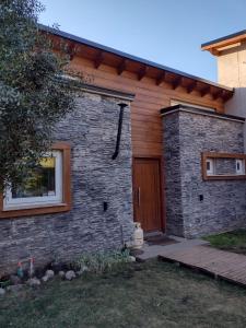 a brick house with a wooden door on it at Casa de montaña in San Carlos de Bariloche
