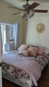 a bedroom with a bed with pink pillows and a ceiling fan at The Nook in Dunlap
