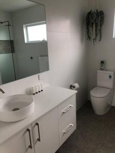 a white bathroom with a sink and a toilet at Cozy on Clinton in Orange