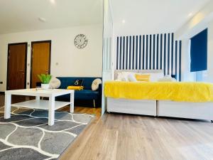 1 dormitorio con cama, sofá y mesa en Park Street Apartment Luton by Hostaguest, en Luton