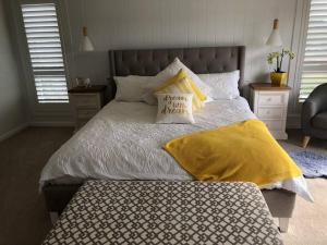 um quarto com uma cama com um cobertor amarelo e almofadas em Armara Views em Orange