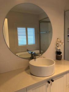 baño con lavabo y espejo grande en Armara Views en Orange