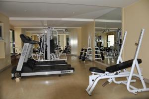 a gym with several tread machines and a mirror at Verona Hplus Long Stay in Brasilia