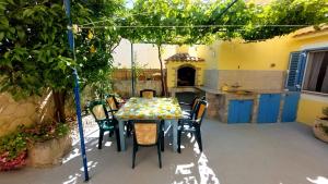 a table and chairs under a pergola in a kitchen at Apartment Nadi - 100 m from sea in Unije