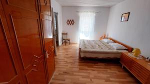Schlafzimmer mit einem Bett und Holzboden in der Unterkunft Apartment Nadi - 100 m from sea in Unije