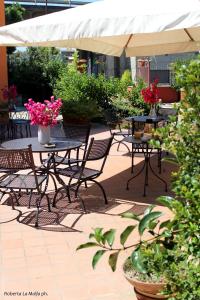 an outdoor patio with tables and chairs and flowers at Il Casale dei Conti in Barcellona-Pozzo di Gotto