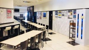 Un comedor con mesas, sillas y carteles. en Toyoko Inn Nagoya Sakae, en Nagoya