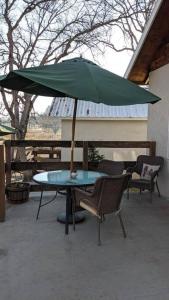 a table with a green umbrella on a patio at Cozy Cabin in Squaw Valley