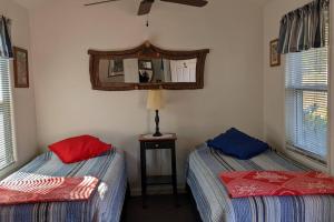 een slaapkamer met 2 bedden en een spiegel aan de muur bij The Apple Place Room #2 in Miramonte