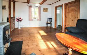 a living room with a couch and a surfboard on the floor at Gorgeous Home In Munka Ljungby With Kitchen 