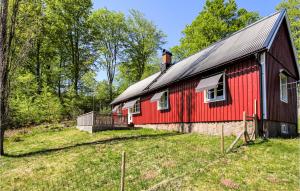 a red barn in the middle of a field at Gorgeous Home In Munka Ljungby With Kitchen 