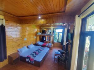 ein Schlafzimmer mit einem Bett in einem Holzzimmer in der Unterkunft Smart Hill Kalatop in Dalhousie