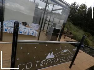 拉塔昆加的住宿－Cotopaxglam，躺在玻璃房子床上的人