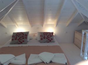 a attic room with two beds and two pillows at Amalia Harbor in Halki