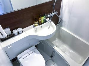 La petite salle de bains est pourvue d'un lavabo et de toilettes. dans l'établissement HOTEL LiVEMAX Shinjuku Kabukicho-Meijidori, à Tokyo