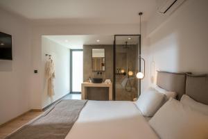 a bedroom with a large white bed and a shower at Stella Palace Aqua Park Resort in Hersonissos