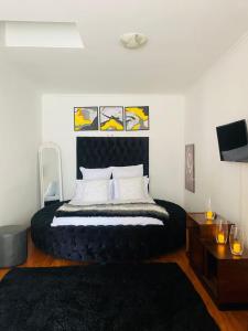 a bedroom with a large bed with a black headboard at Selina Airport Lodge #Emzini in Kempton Park