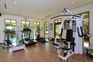 una palestra con tapis roulant e macchine in una stanza di Andaman White Beach Resort - SHA Plus a Nai Thon Beach