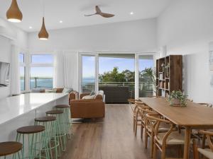 a kitchen and living room with a table and chairs at Tea Trees in Woolgoolga