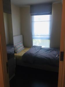 a small room with a bed and a window at Liv at 5 room41 in Bangkok +4 photos