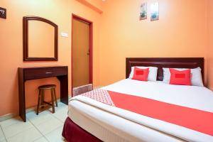 a bedroom with a bed with red pillows and a mirror at Ipoh Times Inn Hotel in Ipoh