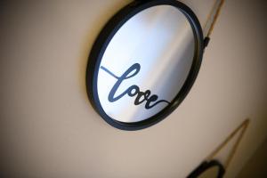 a mirror hanging on a wall with the word love written at Louloudis Apartment in Limenas